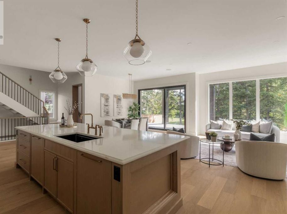 Kitchen with large island, pendant lighting, and integrated appliances in a Calgary custom home