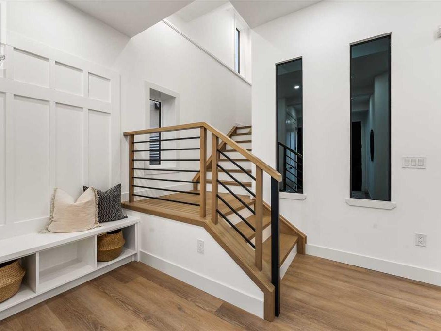 Staircase with black metal railing and recessed lighting in a Patterson custom home
