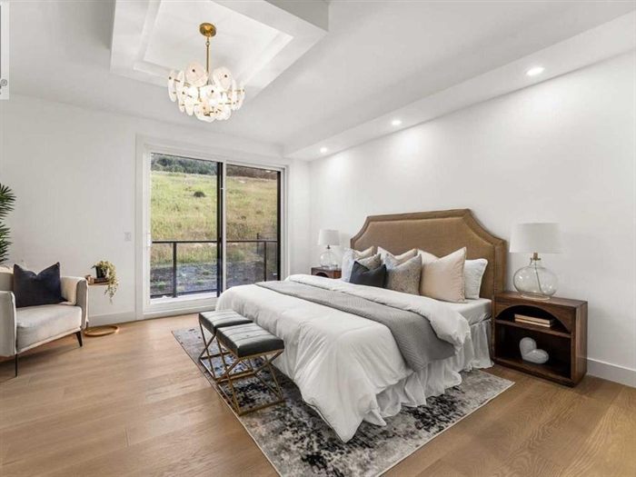 Primary bedroom with chandelier and recessed lighting