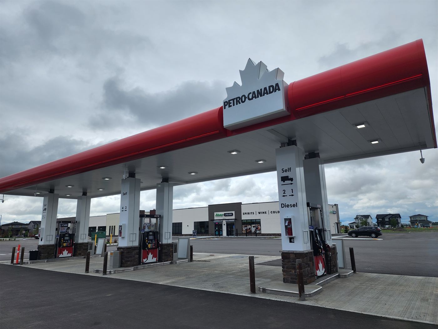 Petro-Canada canopy sign with fuel pumps and the convenience store at the Langdon station