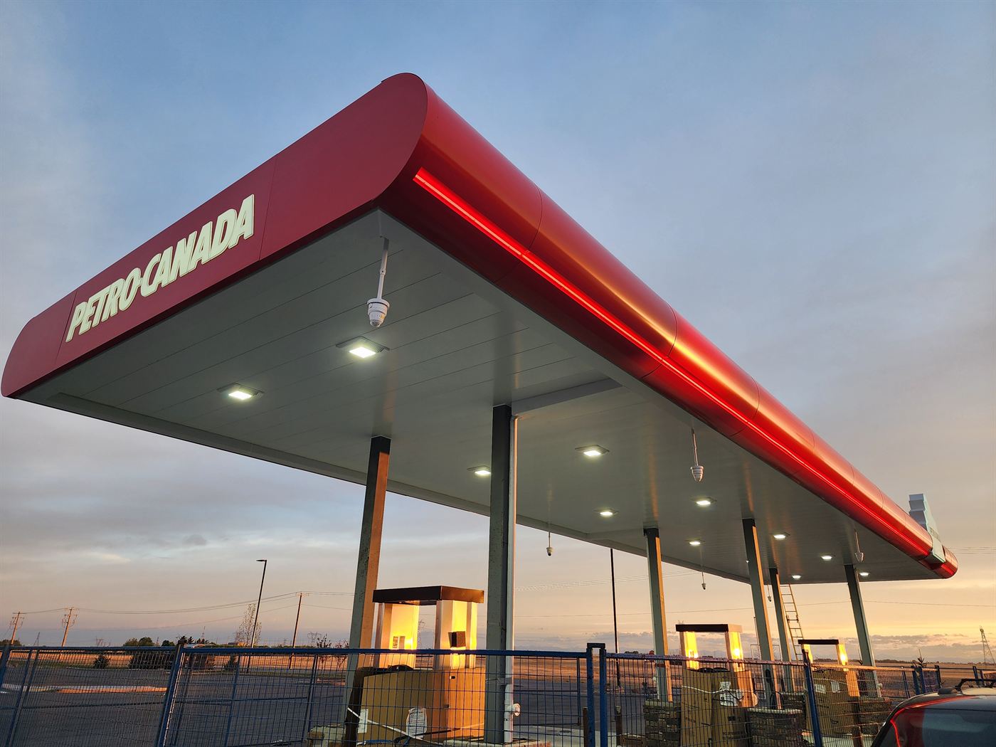Petro-Canada canopy at dusk with LED lighting and construction fencing around the new Langdon site