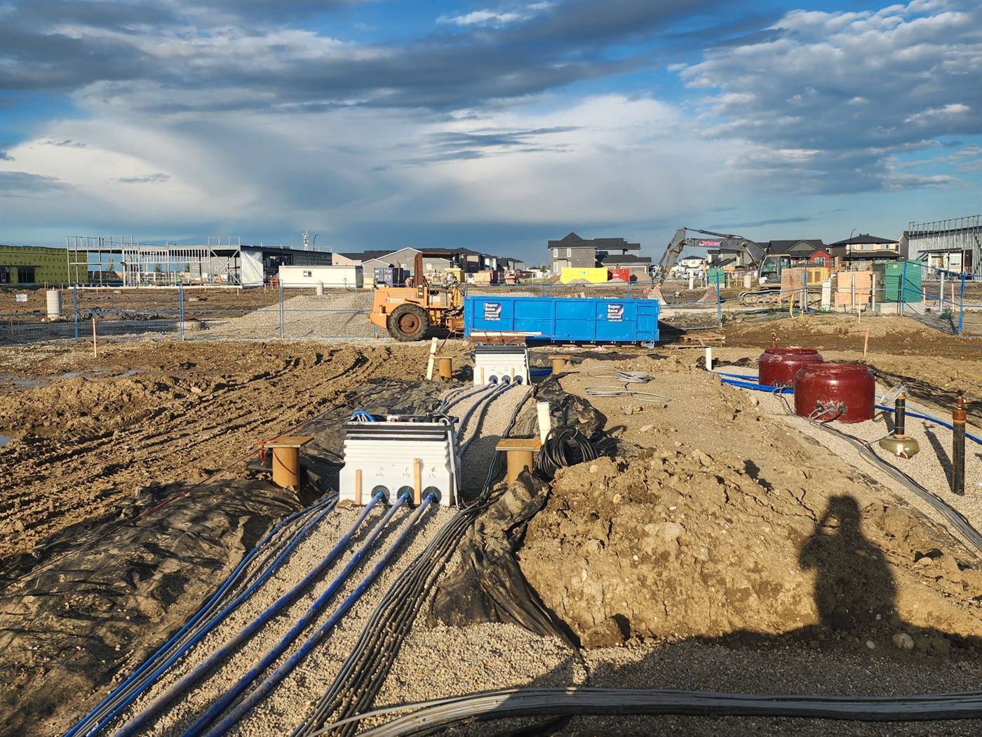 Blue conduit and concrete utility vaults during underground electrical work at the Langdon station site